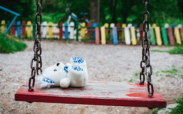Illustrative. A teddy bear lies on an empty swing in the park. (iStock)