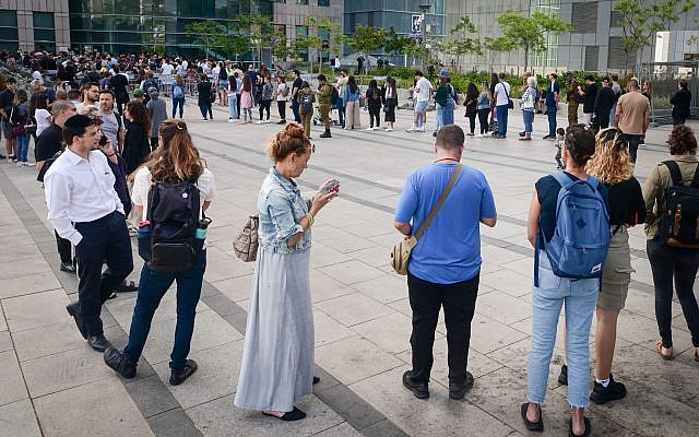 Illustrative. People line up outside the Interior Ministry office to renew their passports, in Tel Aviv, on May 14, 2023. (Avshalom Sassoni/FLASH90)