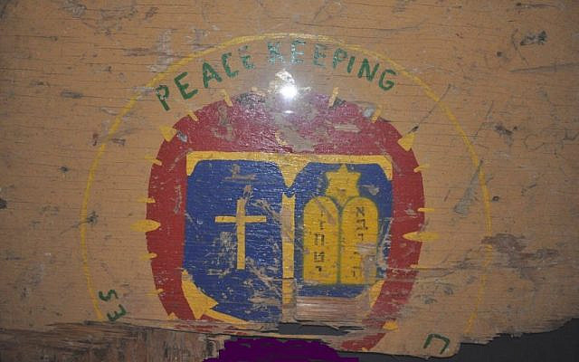Plaque from the chapel in Beirut: peacekeeping, above, the ideal; charred wood below: the reality, the attack