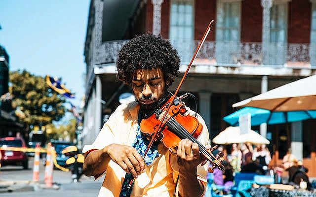 A man playing the violin or fiddle on the streets – Photo by William Recinos on Unsplash
