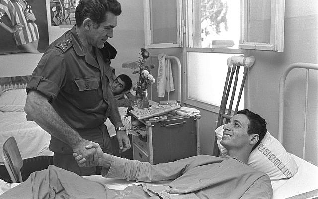Illustrative. Then-chief of staff David Elazar speaks with one of the repatriated wounded Israeli POWs at the Tel HaShomer Hospital, on November 16, 1973. (Ron Ilan/GPO)