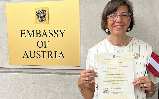 Jennifer Laszlo Mizrahi holds up her new Austrian citizenship while at the Embassy of Austria in Washington, DC. Photo credit & courtesy of JLM.