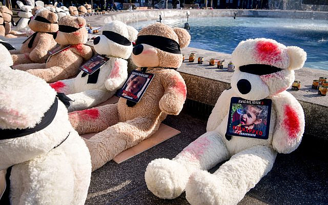 Large teddy bears painted with red paint and carrying photographs of the children held hostage by Hamas terrorists in Gaza, at Dizengoff Square. October 25, 2023. (Avshalom Sassoni/Flash90)