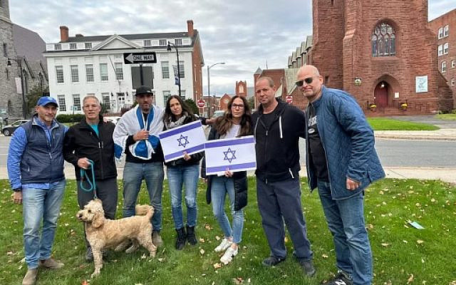 Friends at Vigil for Israel in Pittsfield, Mass earlier this month. Shimi, pictured with Israeli flag on his shoulders, is mourning family members massacred on October 1 at Kibbutz Be’eri. The author is at the far right.