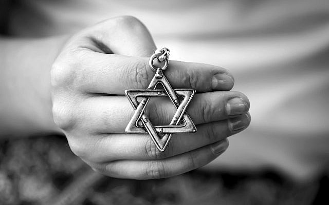 A woman's hand holding a Star of David. (Shutterstock)