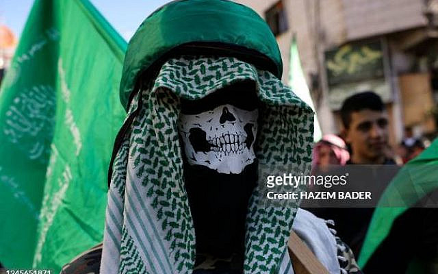 A masked supporter of the Hamas movement, takes part in a rally in the West Bank village of Beit Omar, to mark the 35th anniversary of the Palestinian militant group, on December 16, 2022. (Photo by HAZEM BADER / AFP) (Photo by HAZEM BADER/AFP via Getty Images)