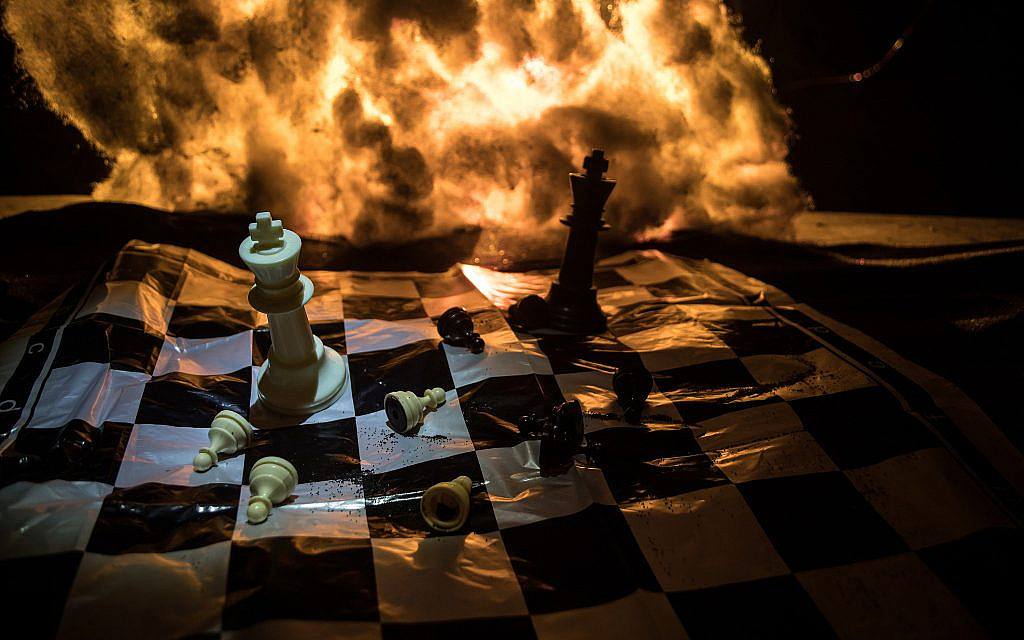 A chessboard against a backdrop of flames. (iStock)