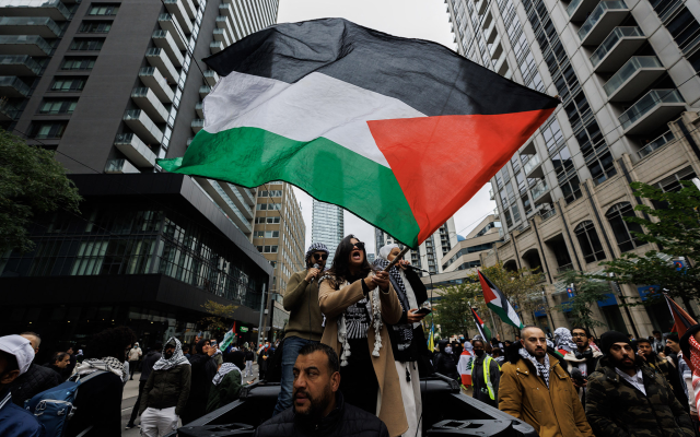 Demonstrators wave Palestinian flags during a protest in Toronto, Ontario, Canada, October 9, 2023. (Cole Burston/AFP)