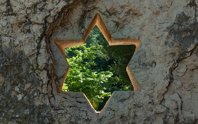 A star of David carved into a rock wall window on the grounds of the Mt. Herzl military cemetery in Jerusalem. (iStock)