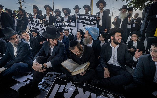 Ultra-Orthodox Jews block a road and clash with police during a protest against the drafting of Ultra orthodox jews to the Israeli army, on road number 4, outside the city of Bnei Brak, April 1, 2024. (Chaim Goldberg/Flash90)