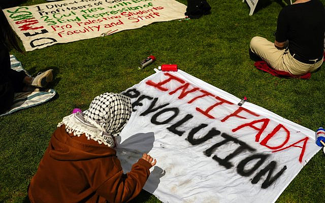 A person prepares a sign reading 'Intifada Revolution' at an anti-Israel encampment at the University of Washington campus, April 29, 2024, in Seattle, Washington. (AP Photo/ Lindsey Wasson)