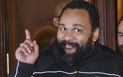 French comedian Dieudonne M’Bala M’Bala gesturing to the media as he leaves a Paris court house, February 4, 2015. (Michel Euler/AP Images/via JTA