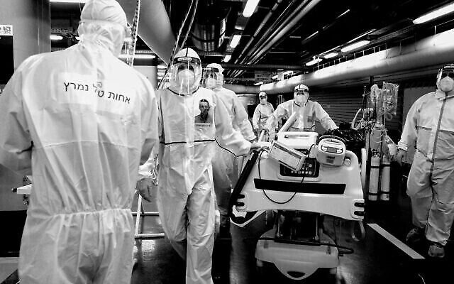 تصویر: کارکنان مگان دیوید آدوم با لباس و تجهیزات حفاظتی در مقابل واحد ویروس کرونای بیمارستان شعاری تصدک در اورشلیم، ۱۱ اکتبر ۲۰۲۰. (Nati Shohat/Flash90)