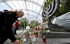تصویر: مردم در روز ۲۹ سپتامبر ۲۰۲۱، هشتادمین سالگرد کشتار «بابی یار»، از بزرگترین کشتارهای یهودیان در جنگ جهانی دوم، پای بنای یادبود «منورا» در کی-یف شمع روشن می کنند. (Sergei SUPINSKY / AFP)