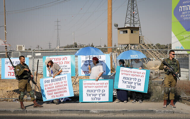 تصویر: مردم اسرائیل حین تظاهرات در «گذرگاه گاش اتزیون»، علیه دیدار نفتالی بنت نخست وزیر با جو بایدن رئیس جمهور ایالات متحده و آنچه به زعم ایشان «توقف توسعهٔ شهرک ها» است؛ ۲۴ اوت ۲۰۲۱. 
(Gershon Elinson/Flash90)