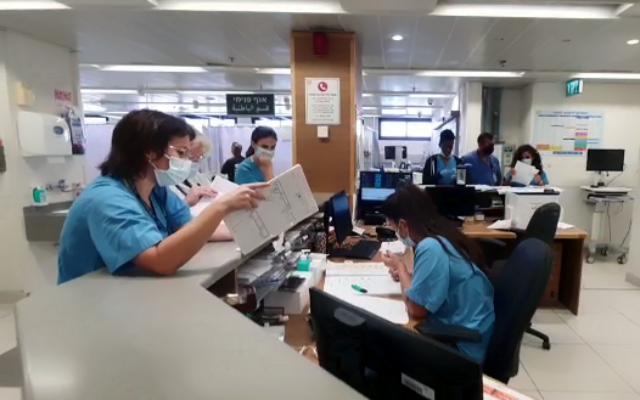 تصویر: در پی حمله سایبری باج افزار به مرکز درمانی هیلل یافه کارکنان بیمارستان حین ثبت اطلاعات بیماران با قلم و کاغذ مشاهده می شوند، ۱۳ اکتبر ۲۰۲۱. (Hillel Yaffe Medical Center)
