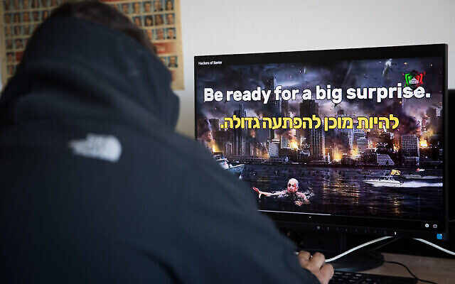 تصویر: مردی در اداره ای در اسرائيل، در حال تماشای ویدئویی در وبسایت اسرائیلی که از سوی گروهی هکر در ایران که خود را «ناجیان هک کننده» می نامند هک شد؛ ۲۱ مه ۲۰۲۰. (Yonatan Sindel/Flash90)