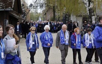 تصویر: بازماندگان هولوکاست در ۲۸ آوریل ۲۰۲۲، در رژهٔ زندگان که در بزرگداشت قربانیان هولوکاست در محل یادبود و در موزهٔ آشویتس-بیرکناو در آوشویچیم. (Wojtek Radwanski/AFP)