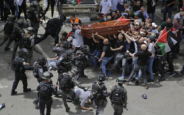 تصویر: جمعه ۱۳ مه ۲۰۲۲، پلیس اسرائیل در تشییع جنازهٔ «شیرین ابوعاقله» خبرنگار مقتول الجزیره در اورشلیم شرقی، با جمعیت عزادارانی که تابوت او را بدوش می کشیدند زدوخورد کرد. (AP Photo/Maya Levin)