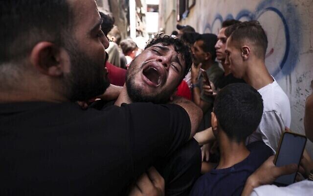 تصویر: واکنش دوست یک فلسطینی جوان که طی شب، در وضعیتی مشکوک در اردوگاه پناهندگان جبلیه در شمال نوار غزه کشته شد، در مراسم سوگواری او در همان کمپ، ۷ اوت ۲۰۲۲. (MAHMUD HAMS / AFP)