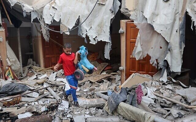 تصویر: یک کودک فلسطینی یک اسباب بازی را از خرابه های خانهٔ خود در شهر رفاه، جنوب نوار غزه، که در آخرین زدوخورد سه روزه با اسرائیل، پیش از آتش بس ویران شد، بیرون کشیده است؛ ۸ اوت ۲۰۲۲. (SAID KHATIB / AFP)