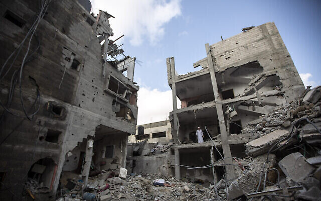 تصویر: فلسطینیان در روز ۷ اوت ۲۰۲۲ در ویرانه های ساختمانی که خالد منصور، از فرماندهان رده بالای جهاد اسلامی بر اثر بمباران رفاه در ناحیهٔ جنوب غزه توسط اسرائیل کشته شد جستجو می کنند. (AP Photo/Yousef Masoud)