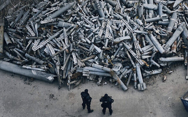 تصویر: افسران پلیس به انبوه قطعات اسقاطی راکت های روسی که به خارکف اصابت کردند می نگرند؛ خارکیف، اوکراین، ۳ دسامبر ۲۰۲۲. (AP Photo/Libkos)