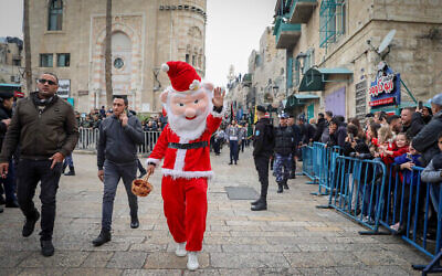 تصویر تزئینی: رژهٔ کریسمس در مقابل کلیسای مهد شهر بیت اللحم کرانه باختری که گمان می رود زادگاه عیسی مسیح باشد، در شب پیش از کریسمس، ۲۴ دسامبر ۲۰۲۲. (Wisam Hashlamoun/Flash90)