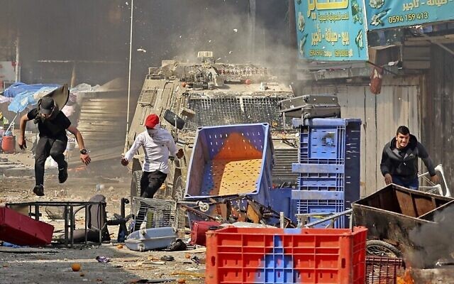تصویر: فلسطینیان حین درگیری با نیروهای امنیتی اسرائيل در یورش ۲۲ فوریهٔ ۲۰۲۳ نیروها  به نابلس.  (Zain Jaafar / AFP)