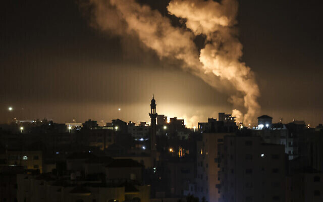 تصویر:‌ با حملهٔ هوایی اسرائیل به تأسیسات حماس در سحرگاه ۱۳ فوریهٔ ۲۰۲۳، آتش و دود از ساختمانی در شهر غزه بهوا برخاسته است. (MAHMUD HAMS / AFP)