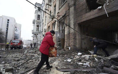 تصویر:‌ شخصی در مرکز شهر خارکف، اوکراین، یکشنبه ۵ فوریهٔ ۲۰۲۳، حین ورود به یک مجموعهٔ مسکونی که در حملهٔ راکتی مسکو تخریب شده است. (AP/Andrii Marienko)