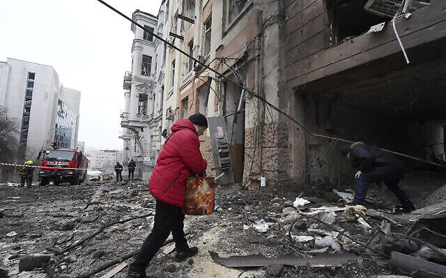 تصویر:‌ شخصی در مرکز شهر خارکف، اوکراین، یکشنبه ۵ فوریهٔ ۲۰۲۳، حین ورود به یک مجموعهٔ مسکونی که در حملهٔ راکتی مسکو تخریب شده است. (AP/Andrii Marienko)