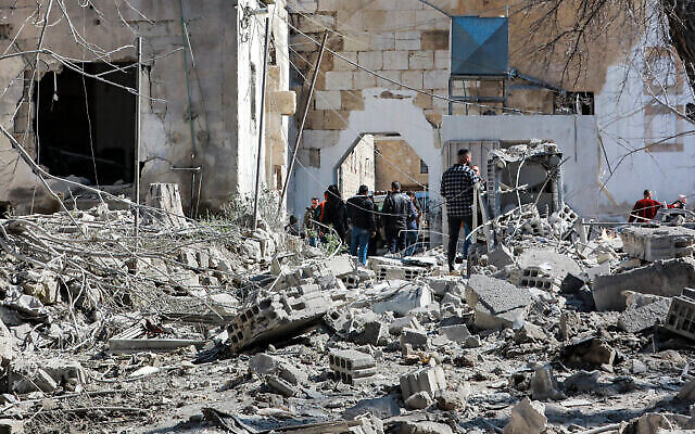 تصویر: مردم حین وارسی ابعاد تخریب در پی حملهٔ هوایی منتسب به اسرائیل در ۱۹ فوریهٔ ۲۰۲۳، که به بنای ارگی در دمشق، بجا مانده از قرون وسطی اصابت کرد. (Louai Beshara/AFP)