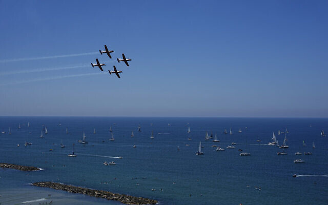 تصویر: جت-های جنگندهٔ اسرائیل در ۲۶ آوریل ۲۰۲۳، حین پرواز نمایشی در هفتادوپنجمین سالگرد استقلال بر فراز قایق-هایی که در دریای مدیترانه، تل آویو، اسرائيل شناورند. (AP Photo/Ariel Schalit)