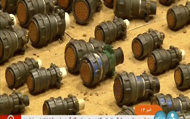 تصویر: در تصویری که در ۳۱ اوت ۲۰۲۳ از کانال تلویزیونی IRINN، شبکهٔ خبری جمهوری اسلامی ایران پخش شد، مقامات مسؤول چیزی که به گفتهٔ آنان قطعهٔ معیوب خارجی است و می-تواند در ساخت موشک و پهباد بکار رود را نشان می-دهند. (IRINN via AP)
