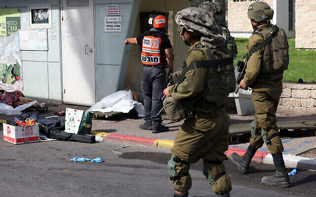 تصاویر ناراحت-کننده – سربازان اسرائیلی از کنار اجساد غیرنظامیان اسرائیلی که به دست تروریست-های غزه در شهر اشکلون، جنوب اسرائیل، ۷ اکتبر ۲۰۲۳. (Oren ZIV / AFP)