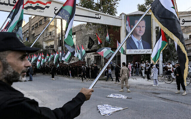 تصویر: اعضای فلسطینی جهاد اسلامی در راهپیمایی ۲۱ اکتبر ۲۰۲۳ در اردوگاه پناهندگی یرموک، جنوب دمشق، پایتخت سوریه، به صف ایستاده و پرچم فلسطین در دست دارند. (LOUAI BESHARA / AFP)