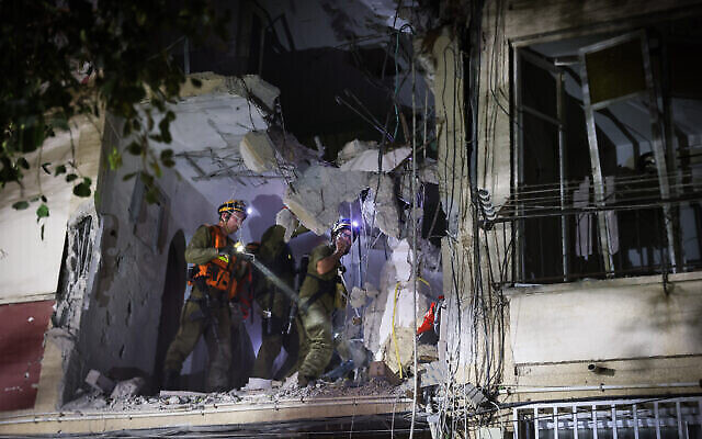 تصویر: امدادگران در محل اصابت راکتی که در ۲۵ اکتبر ۲۰۲۳ از غزه پرتاب شد و به ساختمانی در ریشون لزیون اصابت کرد. (Yossi Aloni/Flash90)