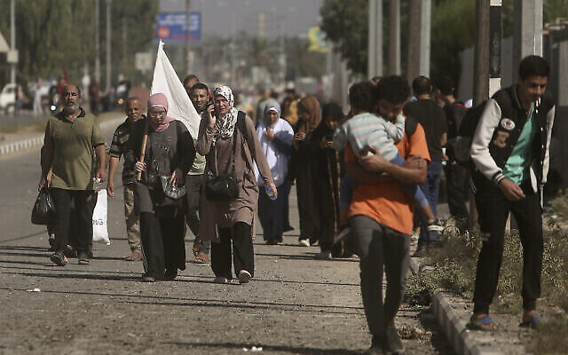تصویر: زنی با پرچم سفید در خیابان صلاح الدین، ناحیهٔ بوریئی، به همراه گروهی از فلسطینیان از شهر غزه به سمت جنوب نوار غزه می-گریزد؛‌ ۷ نوامبر ۲۰۲۳. (AP Photo/Mohammed Dahman)
