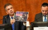تصویر: الی کوهن وزیر خارجهٔ اسرائیل در کنفرانس مطبوعاتی ۱۴ نوامبر ۲۰۲۳ در بنای سازمان ملل در ژنو، تصاویری از تسلیحات تروریست-ها که نیروهای دفاعی در بیمارستان-های غزه یافتند را نشان می-دهد. (Pierre-Michel Virot/Israeli delegation to the UN Offices in Geneva)