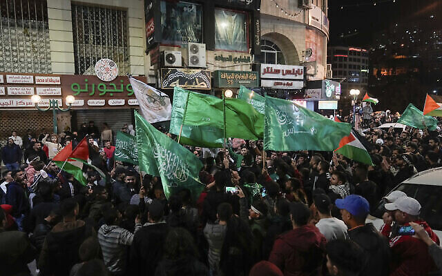 تصویر: فلسطینیان در ۲۴ نوامبر ۲۰۲۳، در جشن آزادی زندانیان فلسطینی در نابلس، کرانهٔ باختری، پرچم حماس در دست دارند. (AP Photo/Majdi Mohammed)
