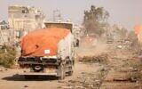 تصویر: خودروهای حامل کمکهای بشردوستانه در جادهٔ صلاح الدین، ناحیهٔ زیتون، دامنهٔ جنوبی شهر غزه، ۲۶ نوامبر ۲۰۲۳. (Mahmud Hams/AFP)
