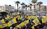 فلسطینیان در راهپمایی ۳۱ دسامبر ۲۰۲۳ در پنجاه و نهمین سالگرد ایجاد جنبش فتح در رام الله، کرانهٔ باختری، پرچم بالا برده-اند. (Zain JAAFAR / AFP)