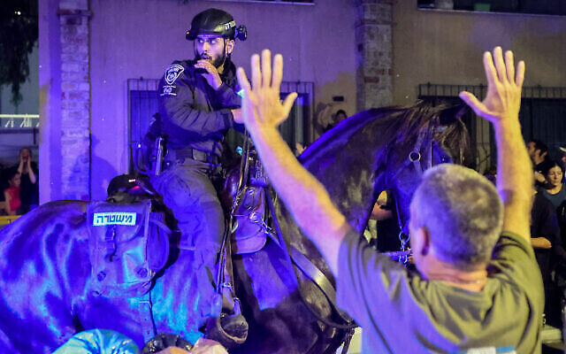 تصویر: پلیس سوارهٔ اسرائیل حین پراکندن معترضان ضد-دولتی در تل آویو، ۲۷ آوریل ۲۰۲۴ در هنگامهٔ جنگ اسرائیل و حماس. (Charlie Summers/Times of Israel)
