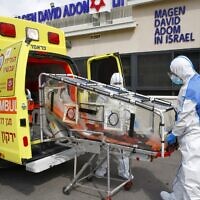 Des secouristes de la Magen David Adom, l'équivalent de la Croix-Rouge en Israël, simulent le transport d'une personne atteinte du nouveau coronavirus, à Kyriat Ono, à l'est de Tel-Aviv, le 26 février 2020. (Crédit : AFP
JACK GUEZ / AFP)