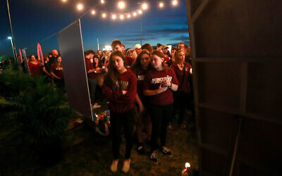 Des personnes se recueillent lors de la commémoration des victimes de la fusillade du 14 février 2019 à Parkland (Floride). (AP Photo/Wilfredo Lee)