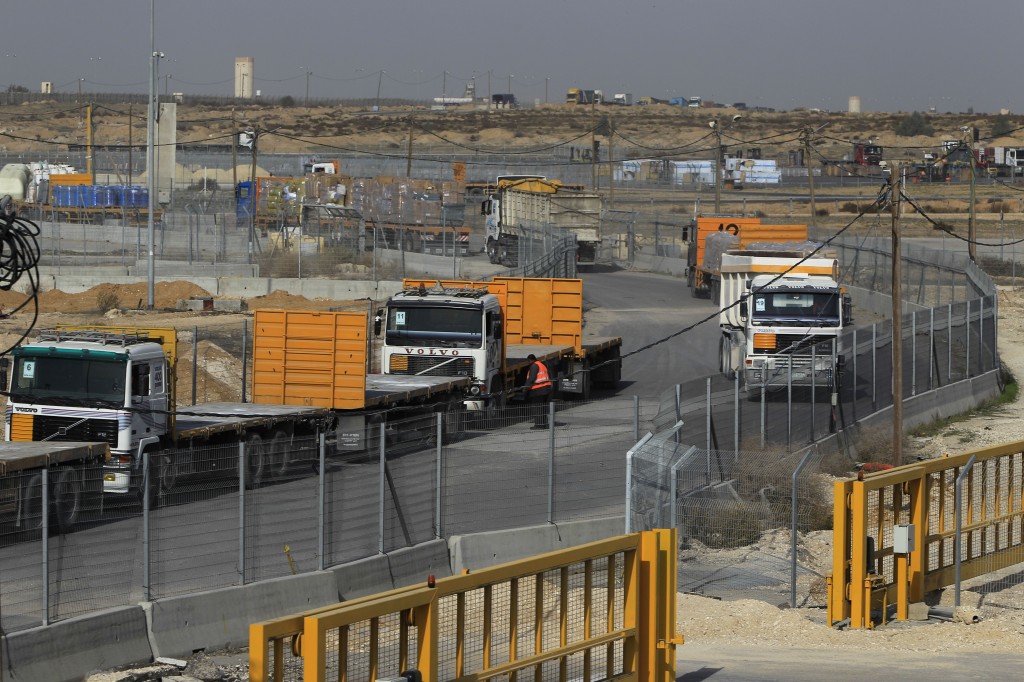 Empty trucks from Gaza wait to be loaded with goods (left) as full trucks drive toward Gaza in the background at the Kerem Shalom crossing between Israel and Gaza last year (photo credit: Tsafrir Abayov/Flash90)