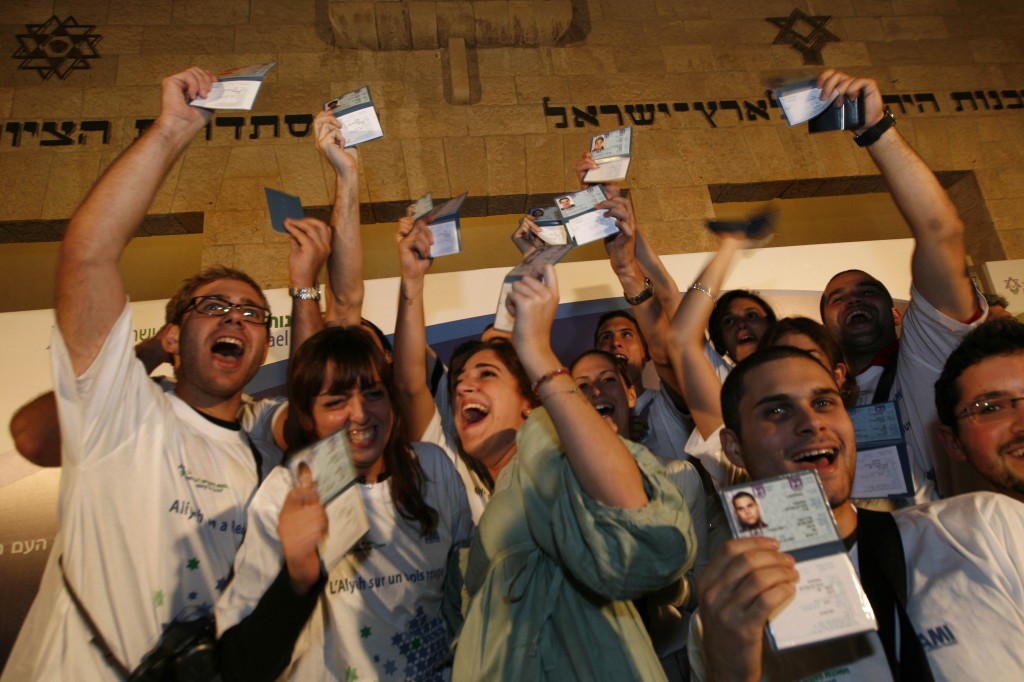 New immigrants to Israel from France hold up their new Israeli ID cards (photo credit: Miriam Alster/Flash90)