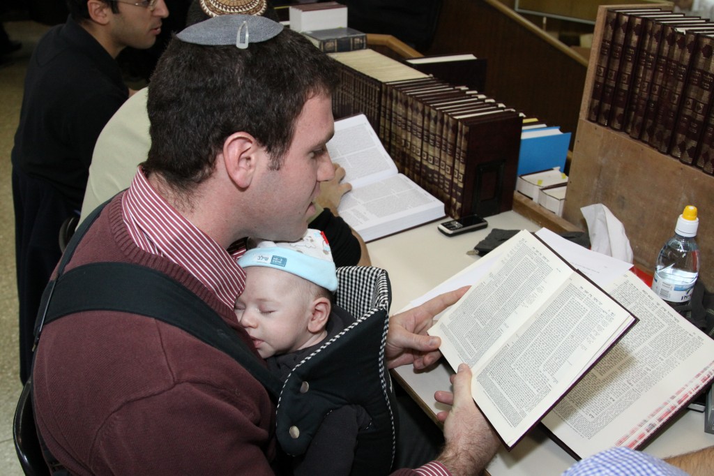 A father wearing his baby while learning (photo credit: Gershon Elinson/Flash 90)
