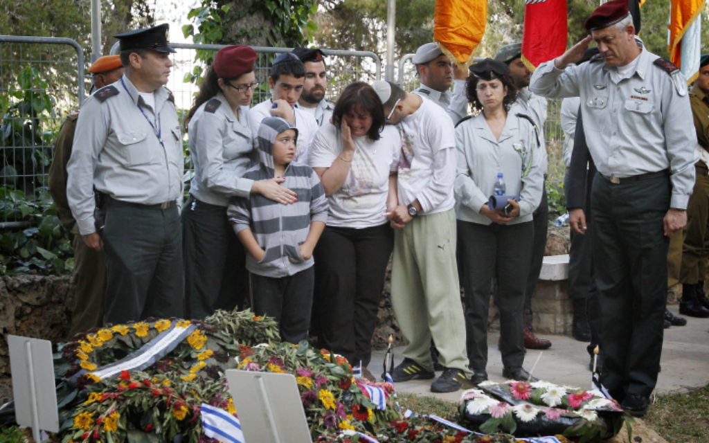Friends and relatives of Hila Betzaleli cry as IDF Chief of General Staff Benny Gantz salutes after laying an Israeli flag on her grave, at the Mount Herzl military cemetery (photo credit: Miriam Alster/Flash90)